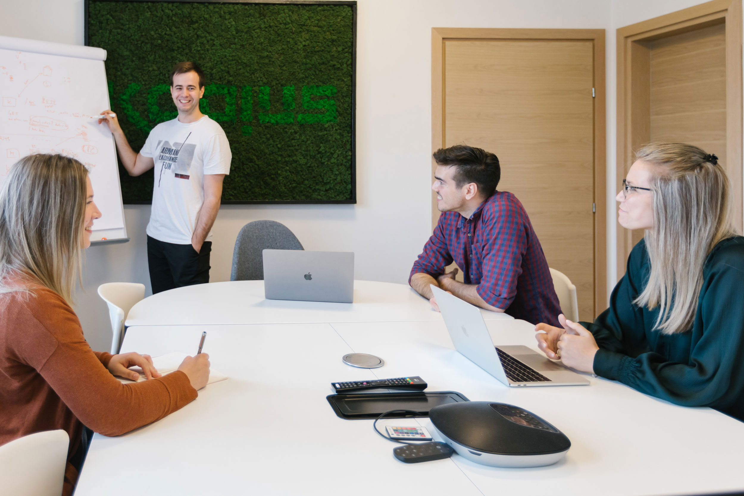 A group of people sitting around a white table.